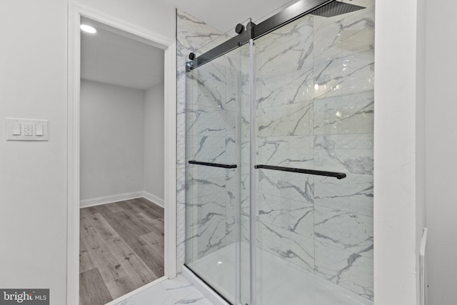 bathroom featuring wood-type flooring and a shower with door