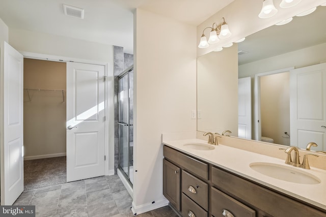 bathroom featuring vanity, toilet, and a shower with door