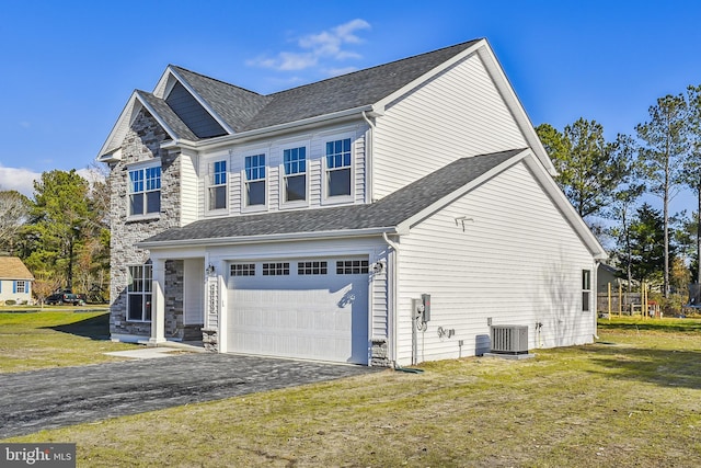 view of front facade featuring cooling unit, a front yard, and a garage