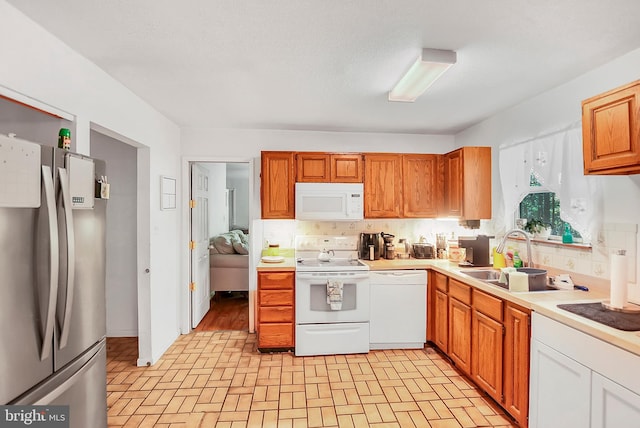 kitchen featuring decorative backsplash, sink, and white appliances