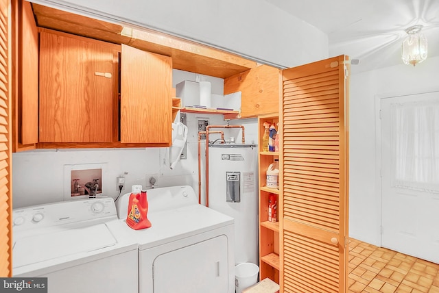 laundry area featuring washer and dryer, electric water heater, and cabinets