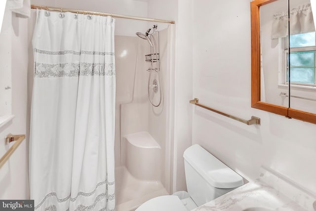 bathroom featuring vanity, toilet, and walk in shower