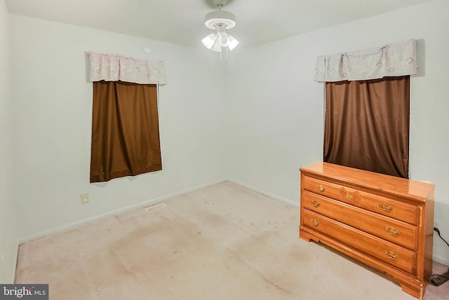 unfurnished bedroom featuring light colored carpet and ceiling fan