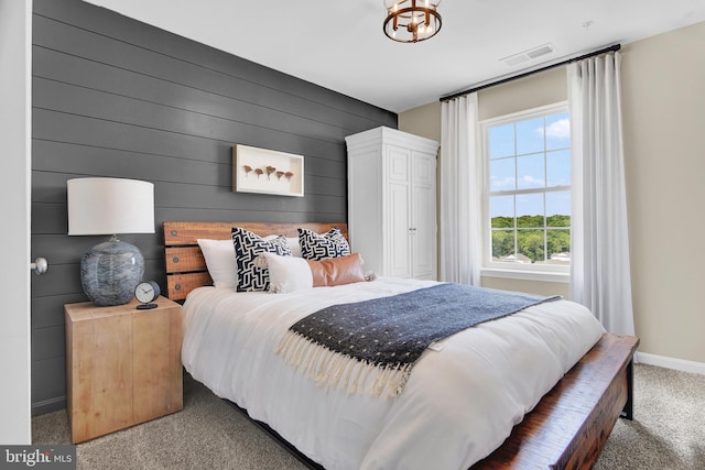 carpeted bedroom with wood walls