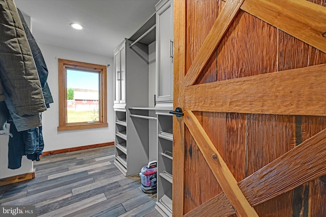 walk in closet with dark wood-type flooring