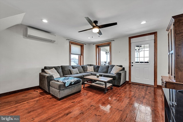 living room with an AC wall unit, dark wood-type flooring, and ceiling fan