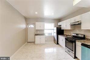 kitchen with ventilation hood, stainless steel appliances, and white cabinetry