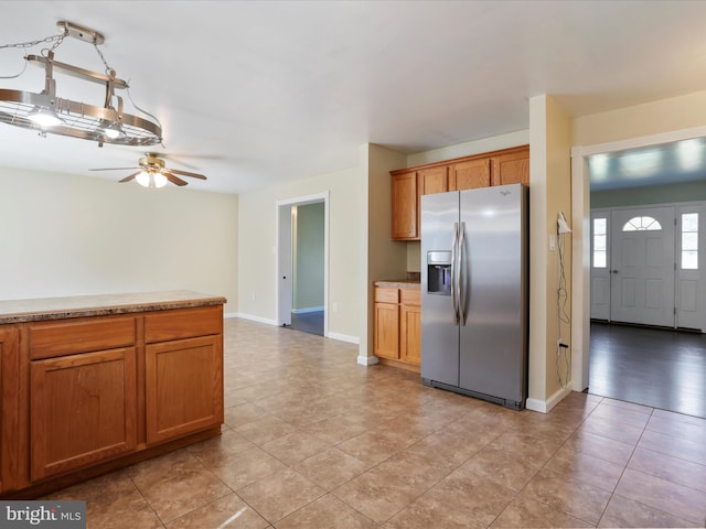 kitchen featuring ceiling fan, light tile patterned flooring, and stainless steel fridge