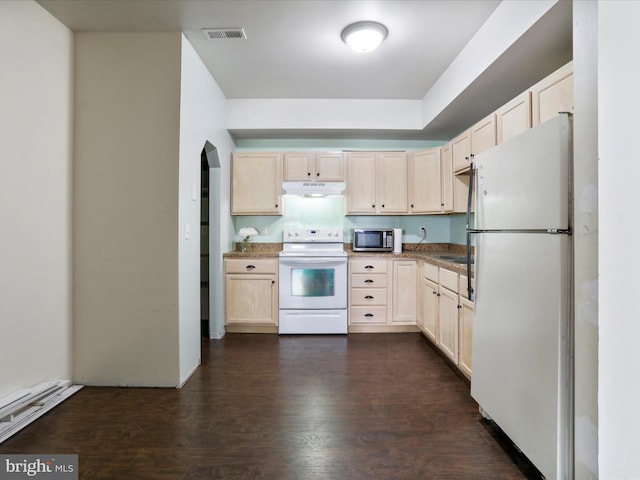 kitchen with light brown cabinetry, dark hardwood / wood-style floors, and white appliances