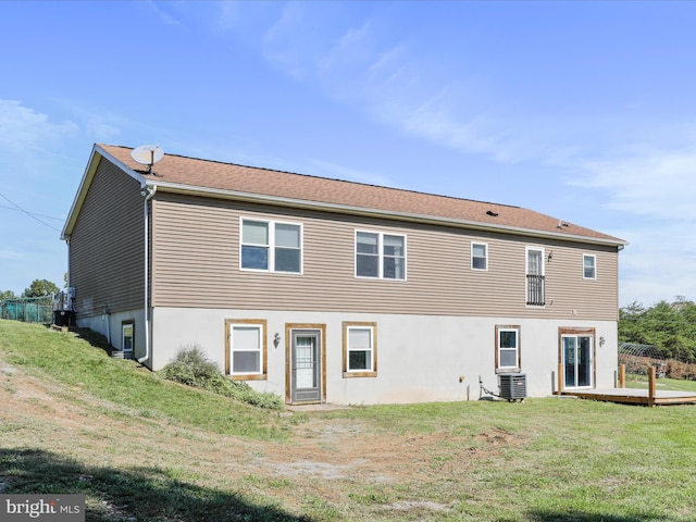 rear view of property with a lawn and central air condition unit