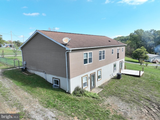 view of side of property featuring cooling unit and a yard