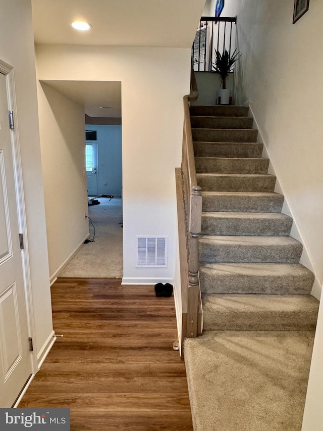 staircase with wood-type flooring