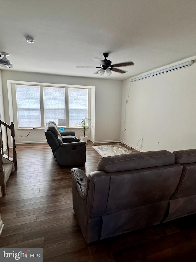 living room featuring ceiling fan and dark hardwood / wood-style flooring