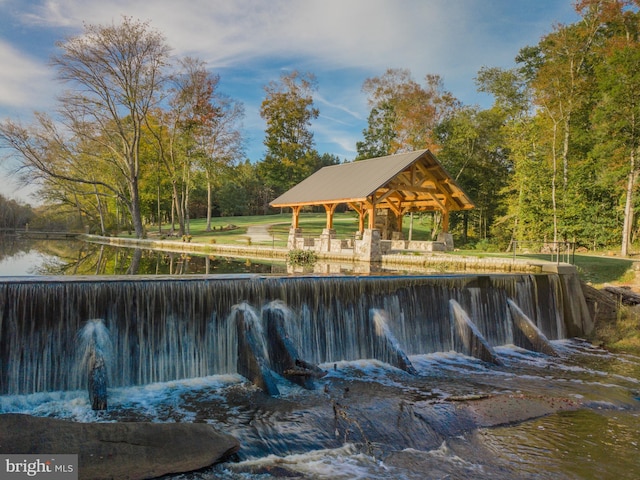 view of swimming pool with a gazebo and a water view