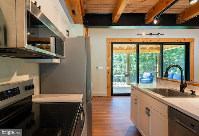 kitchen with white cabinets, beam ceiling, sink, appliances with stainless steel finishes, and wooden ceiling