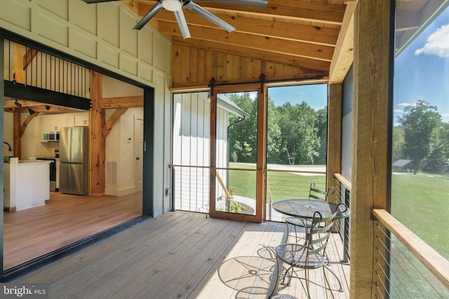 unfurnished sunroom with ceiling fan and vaulted ceiling with beams