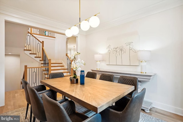 dining space with light wood-type flooring and ornamental molding