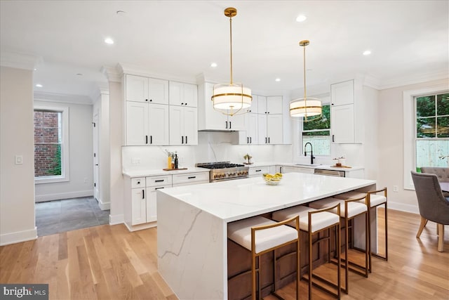 kitchen featuring light hardwood / wood-style flooring, plenty of natural light, white cabinetry, and a center island