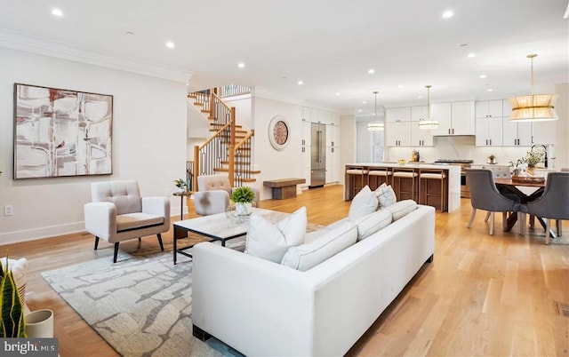 living room featuring ornamental molding and light wood-type flooring