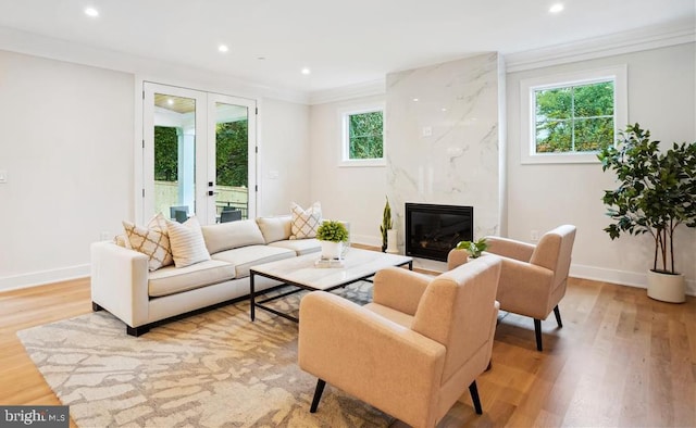 living room with ornamental molding, light hardwood / wood-style floors, and a healthy amount of sunlight