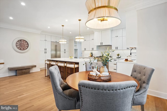 dining space featuring crown molding and light hardwood / wood-style floors