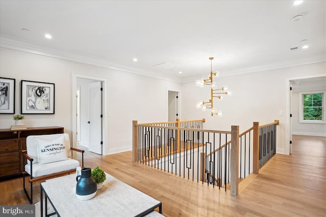 corridor featuring an inviting chandelier, light wood-type flooring, and crown molding