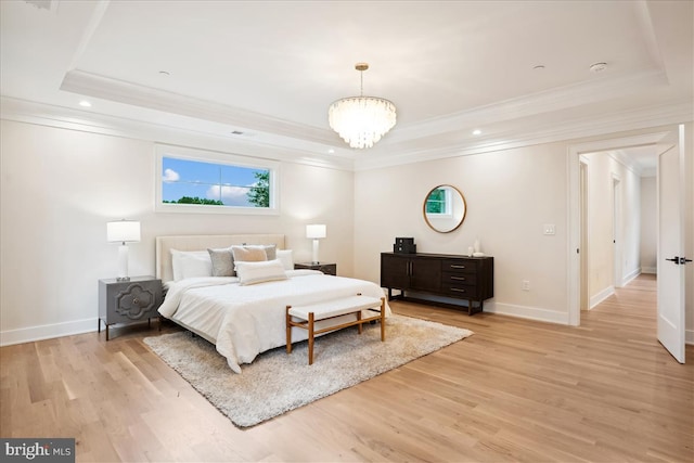 bedroom with an inviting chandelier, light hardwood / wood-style floors, a raised ceiling, and ornamental molding