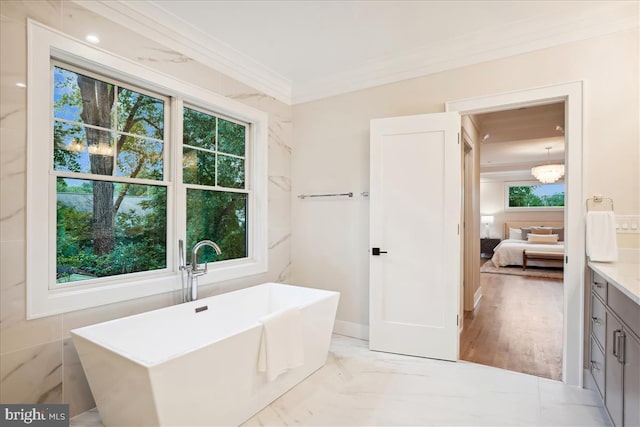 bathroom with vanity, crown molding, hardwood / wood-style flooring, and a tub