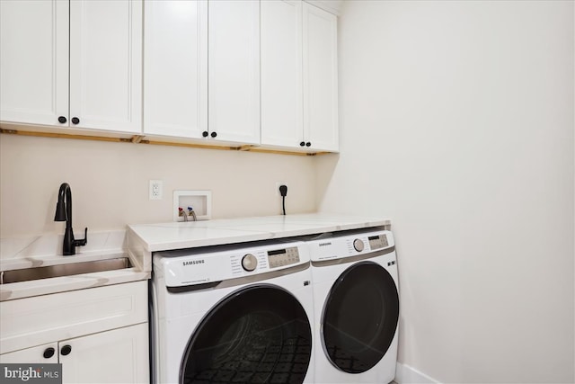 laundry area featuring cabinets, separate washer and dryer, and sink