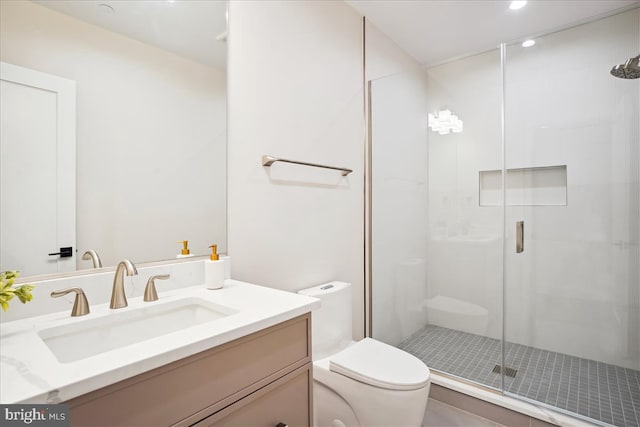 bathroom with a shower with door, vanity, and toilet