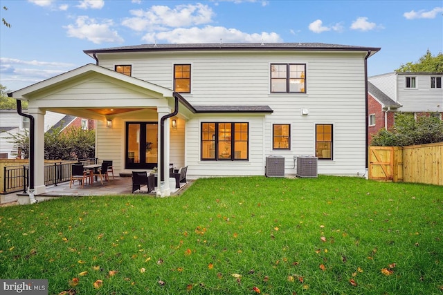 rear view of house with a lawn, a patio, and central AC unit