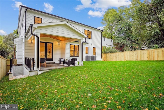 back of house with a lawn and a patio