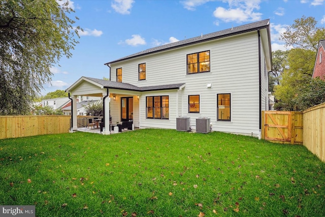 back of property featuring a lawn, a patio, and central air condition unit