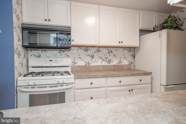 kitchen featuring white cabinets and white appliances