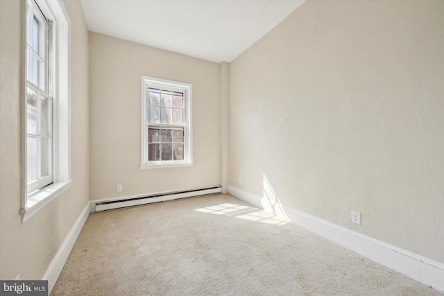 carpeted empty room featuring a baseboard heating unit