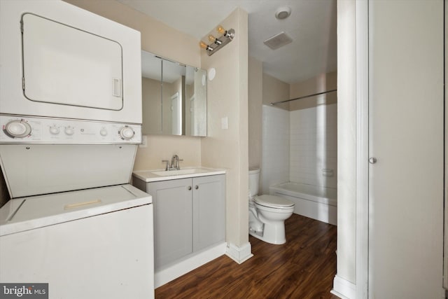 interior space with dark hardwood / wood-style flooring, stacked washer / drying machine, and sink