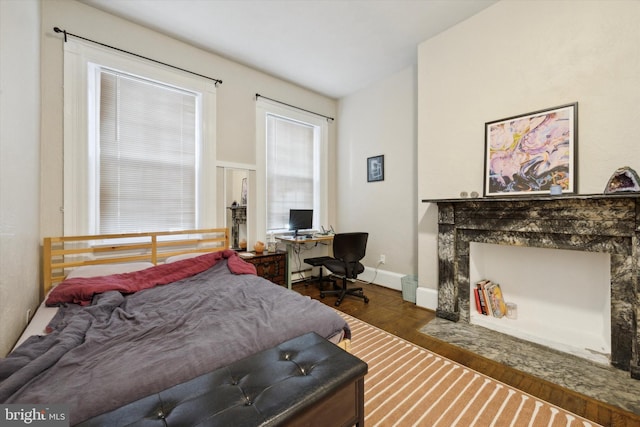 bedroom featuring dark hardwood / wood-style floors and a premium fireplace