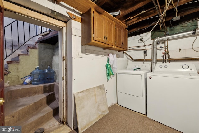 laundry room with separate washer and dryer, cabinets, and light carpet