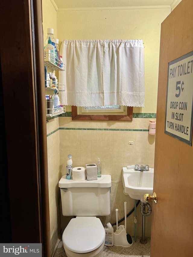 bathroom with tile walls, sink, and toilet