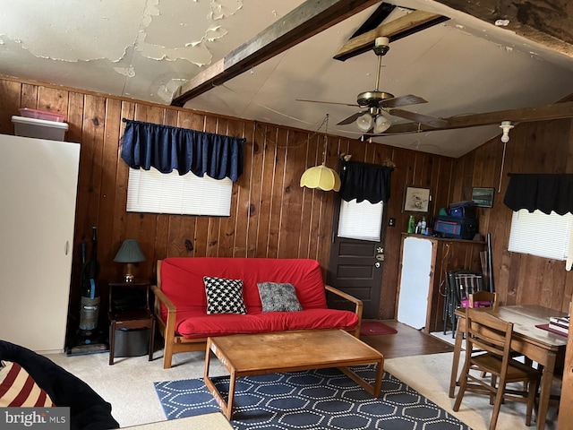 living room featuring ceiling fan, wood walls, and a wealth of natural light