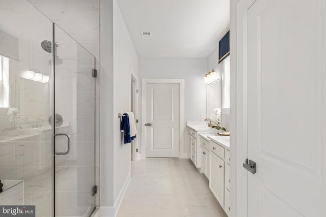 bathroom featuring a shower with door and vanity