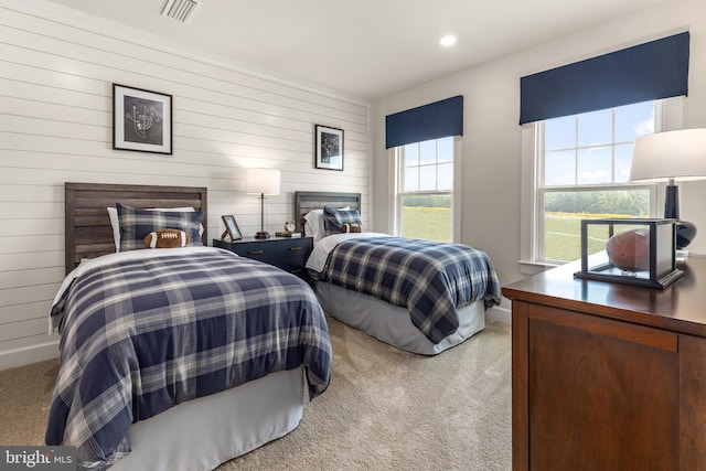 carpeted bedroom featuring wooden walls