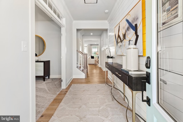 foyer entrance with light hardwood / wood-style floors and ornamental molding