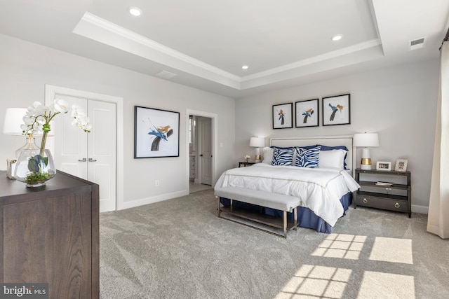 bedroom featuring a tray ceiling and light colored carpet