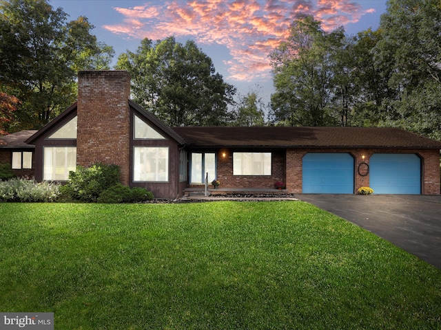 view of front of property featuring a yard and a garage