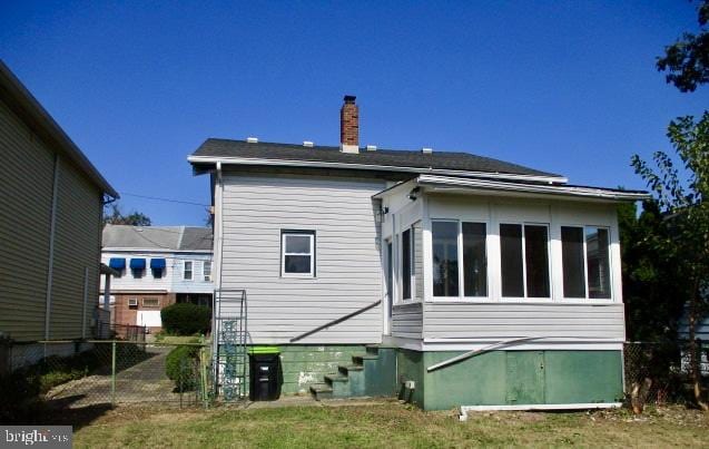 back of property with a sunroom