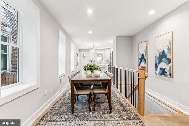 dining area with dark wood-type flooring and a chandelier