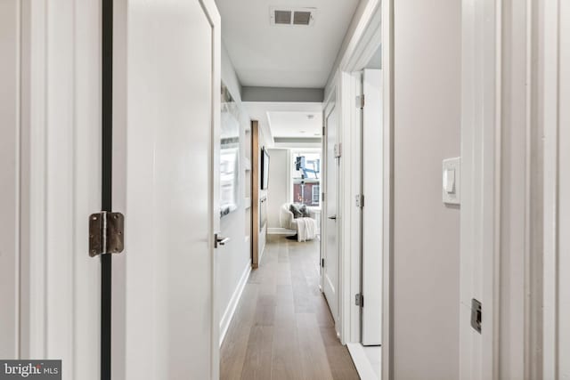 hallway with light hardwood / wood-style flooring