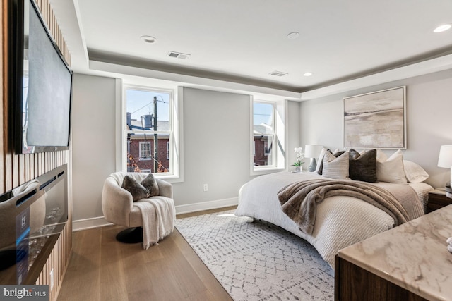 bedroom featuring multiple windows and wood-type flooring