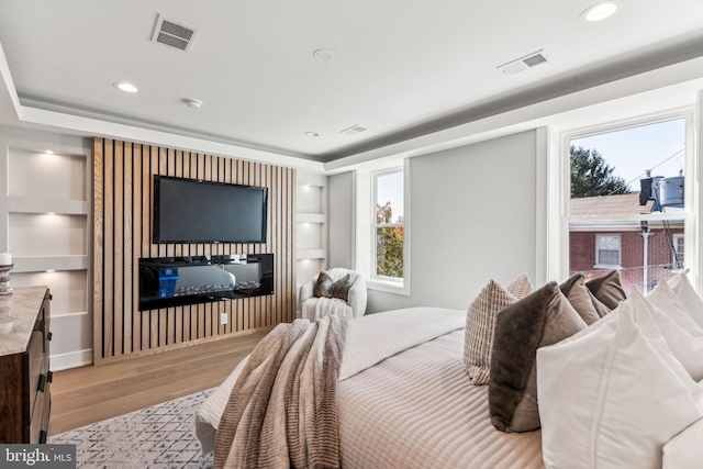 bedroom with multiple windows and light wood-type flooring